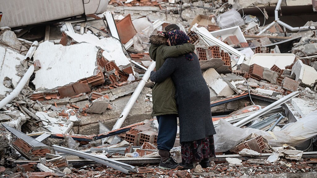 Hatay, Türkiye - FEBRUARY 07: Women hug each other near the collapsed building on February 07, 2023 in Hatay, Türkiye  A 7.8-magnitude earthquake hit near Gaziantep, Türkiye , in the early hours of Monday, followed by another 7.5-magnitude tremor just after midday. The quakes caused widespread destruction in southern Türkiye  and northern Syria and were felt in nearby countries. (Photo by Burak Kara/Getty Images)