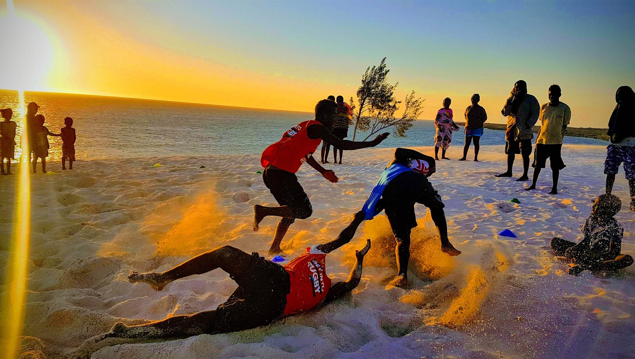 TERRES EN MÊLÉES - young people playing rugby on the beach